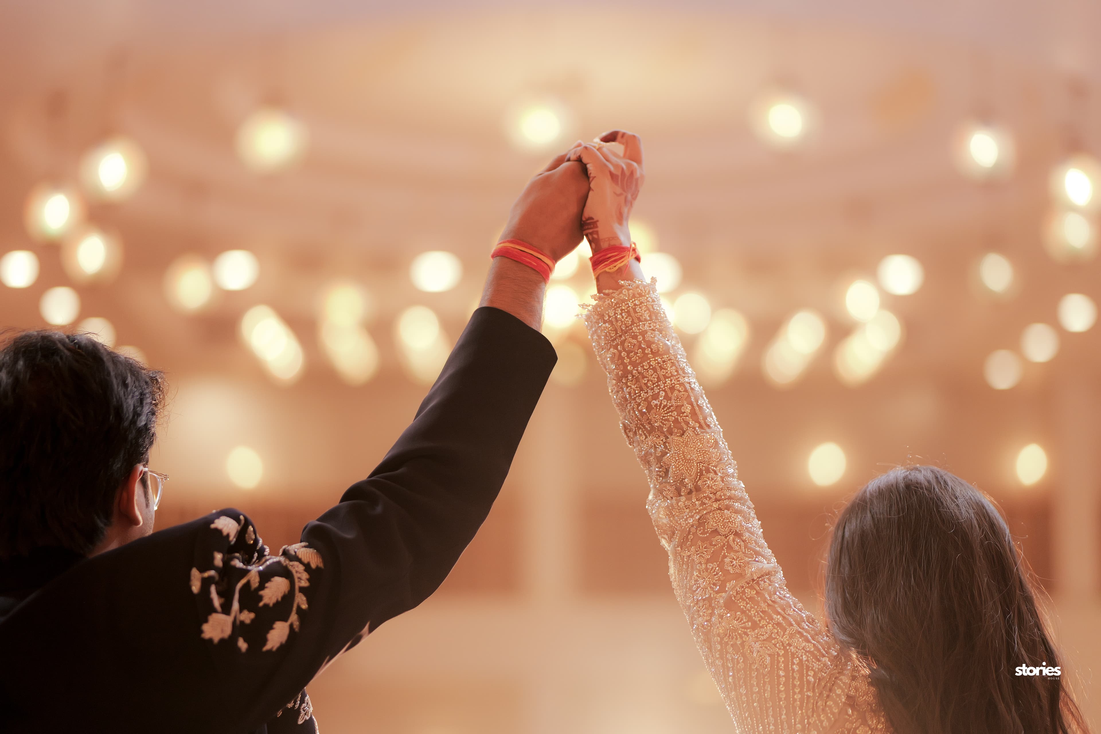 A couple celebrating beneath warm wedding lights